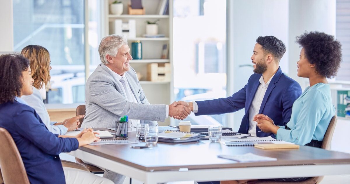 Business buyer and seller shaking hands after negotiating the purchase of a business. The final selling price depends on the agreed transaction terms.