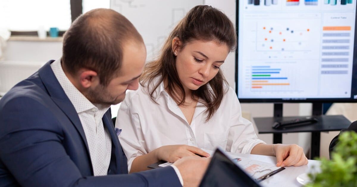Business valuation professionals reviewing financial information and company performance